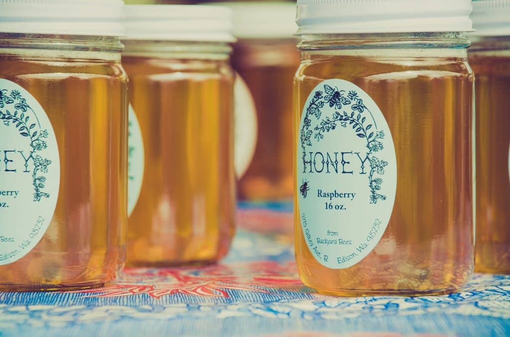 A couple jars of honey on a table